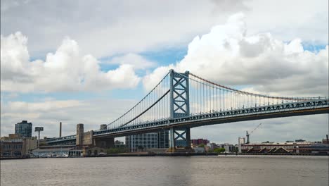 Benjamin-Franklin-Bridge-Zeitraffer-An-Einem-Bewölkten,-Warmen-Tag-über-Dem-Delaware-River-Von-Camden,-New-Jersey