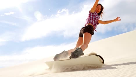 Woman-sand-boarding-on-the-slope-in-desert-4k