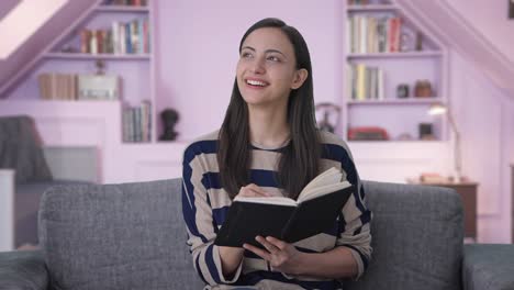 chica india feliz escribiendo un libro