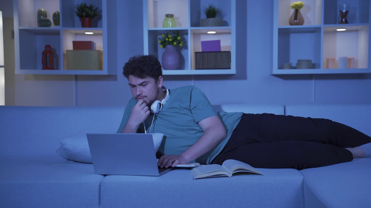 Stressed and depressed male student at home at night.