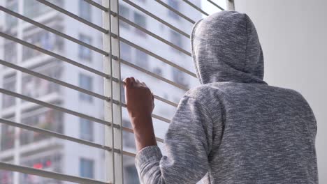 sad teenage boy looking through window