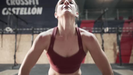 mujer haciendo flexiones en un gimnasio