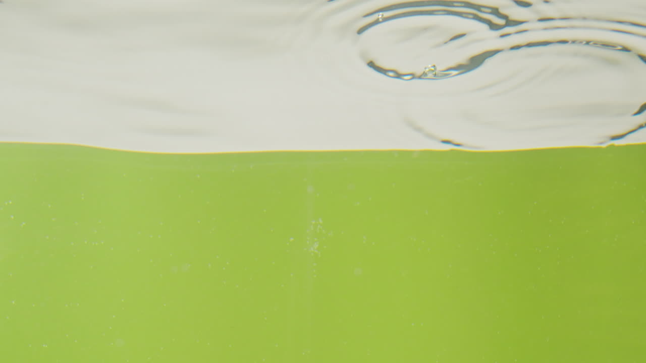 Water Splashing into Green Liquid