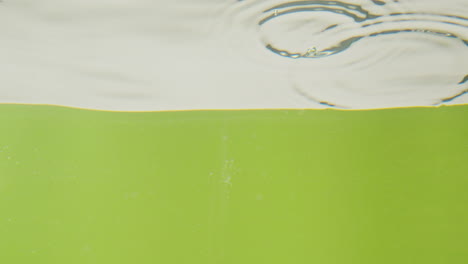 water splashing into green liquid