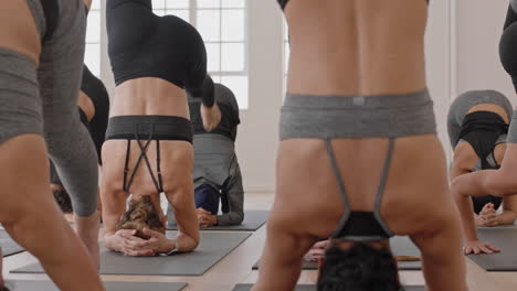 grupo de clase de yoga de mujeres multirraciales que practican postura de parada de cabeza apoyada disfrutando de un estilo de vida saludable haciendo ejercicio en la meditación del gimnasio