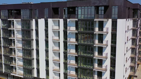 facade of new block of flats. modern design of black and white multi storey architecture in the city. beautiful high-raise building with balconies and tall windows.