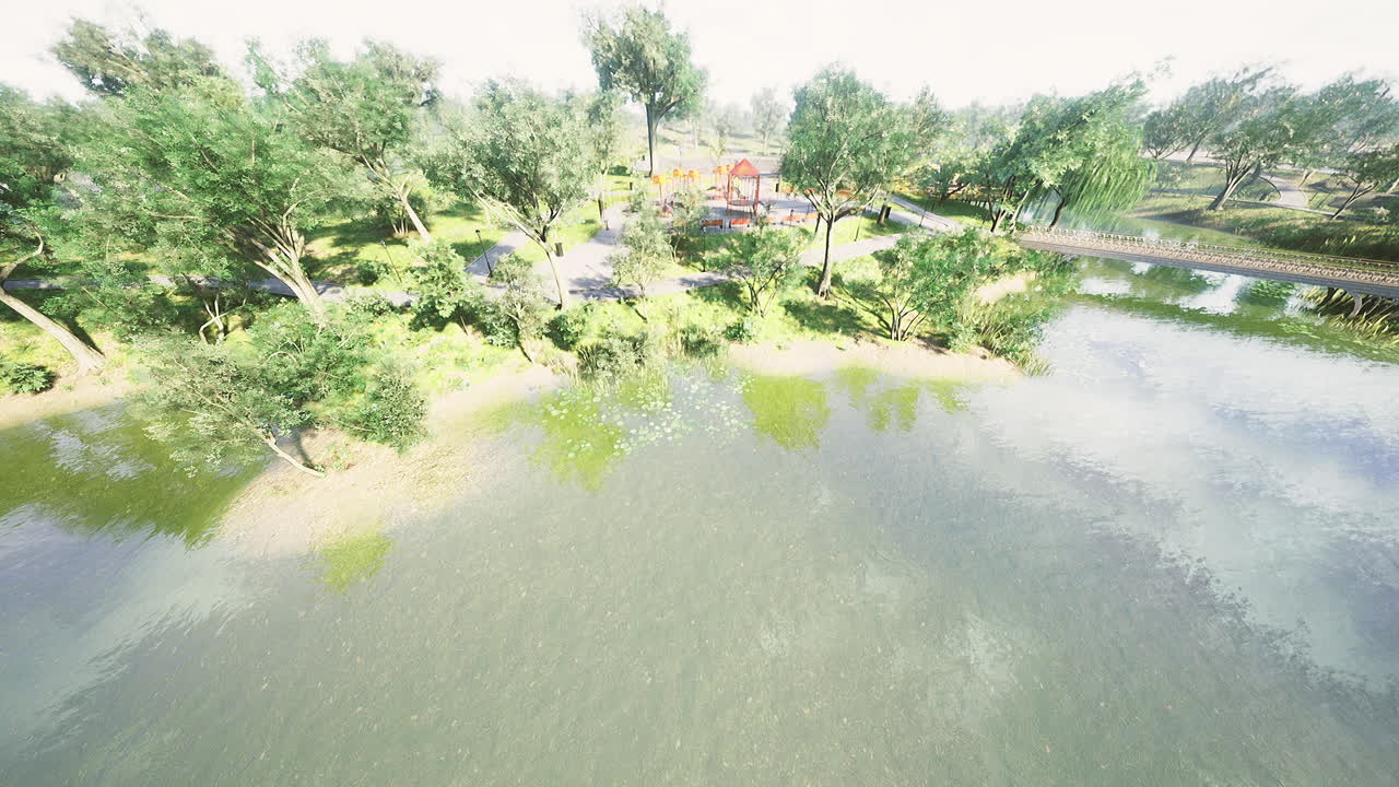 Lush riverside park with greenery and calm water under bright sunlight