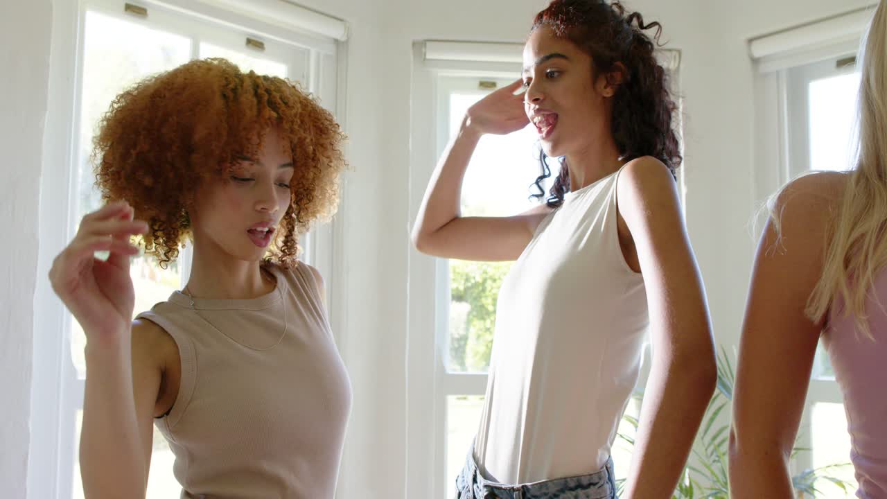 Mulheres afro-americanas modelando para fotógrafo, fazendo gestos e arrumando o cabelo perto de janelas salientes