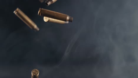 numerous spent ammunition casings falling through smoky haze