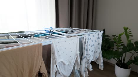 shot of wet baby clothes on a dryer at home in the room