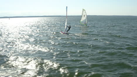 a fantastic view of a couple of windsurfers floating on the open water