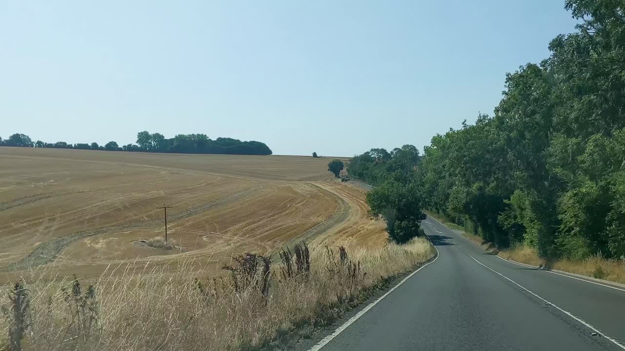 드라이빙 포인트 오브 뷰 부드러운 자동차 대시캠은 불태운 들판과 푸른 하늘 도르셋 영국 4k를 지나서 촬영했습니다.