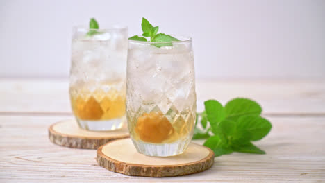 Jugo de ciruela helado con soda y menta en la mesa de madera - bebida refrescante