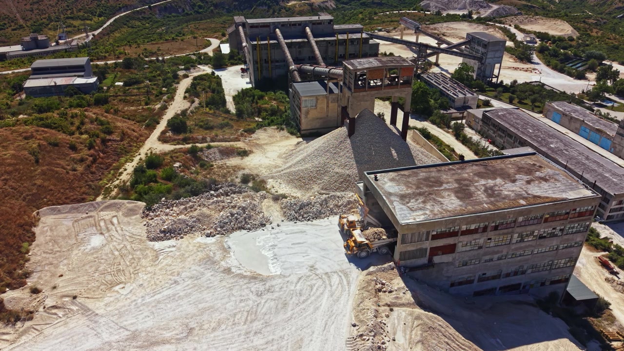 Construction site with machinery and buildings on a hillside