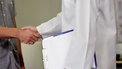 patient shaking hands with physiotherapist