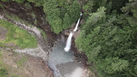 God-view-of-a-beautiful-waterfall-and-surrounding-evergreen-forest,-aerial