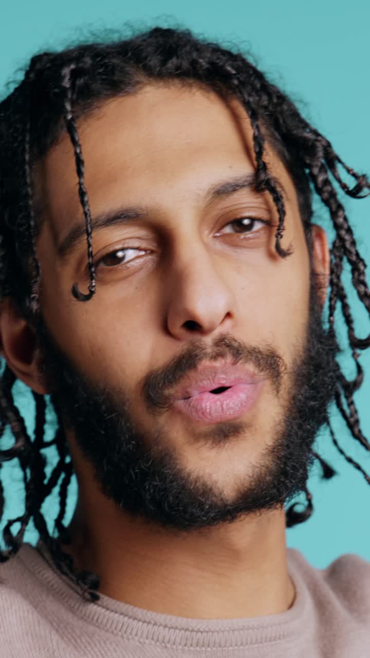 Vertical video Man blowing kisses to camera, being flirty, studio background