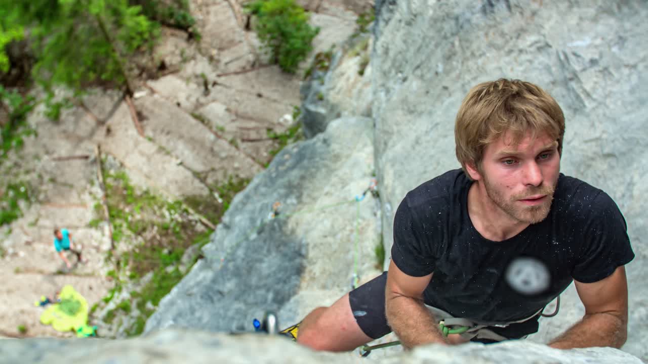 Extreme sport. Handsome young man rock climber grip with hand. close-up