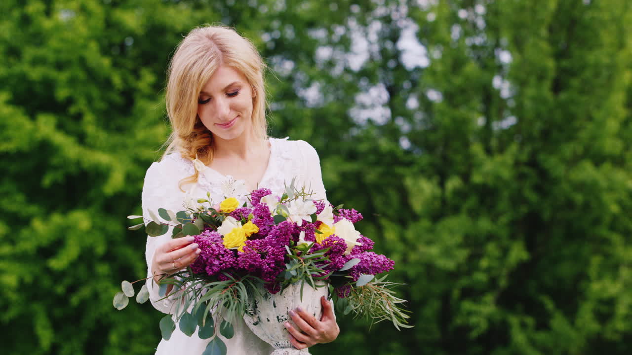atractiva joven posando en el bosque con un ramo de flores silvestres de primavera