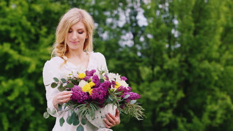 Attraktives-Junges-Mädchen-Posiert-Im-Wald-Mit-Einem-Strauß-Frühlingsblumen