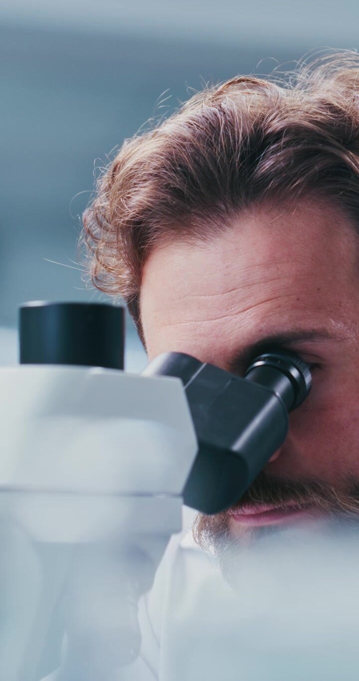 Uno scienziato che guarda attraverso un microscopio in un laboratorio