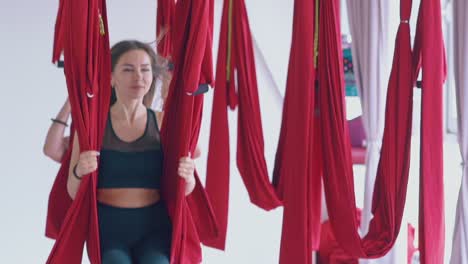 pretty dark haired lady swings holding fly yoga hammock