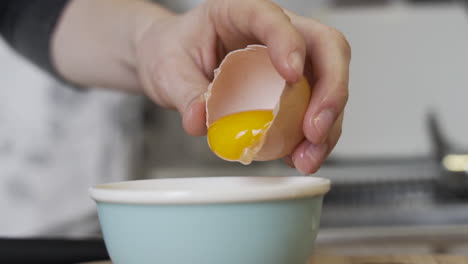 separando el huevo amarillo, la yema en un bol como preparación para hornear en la cocina