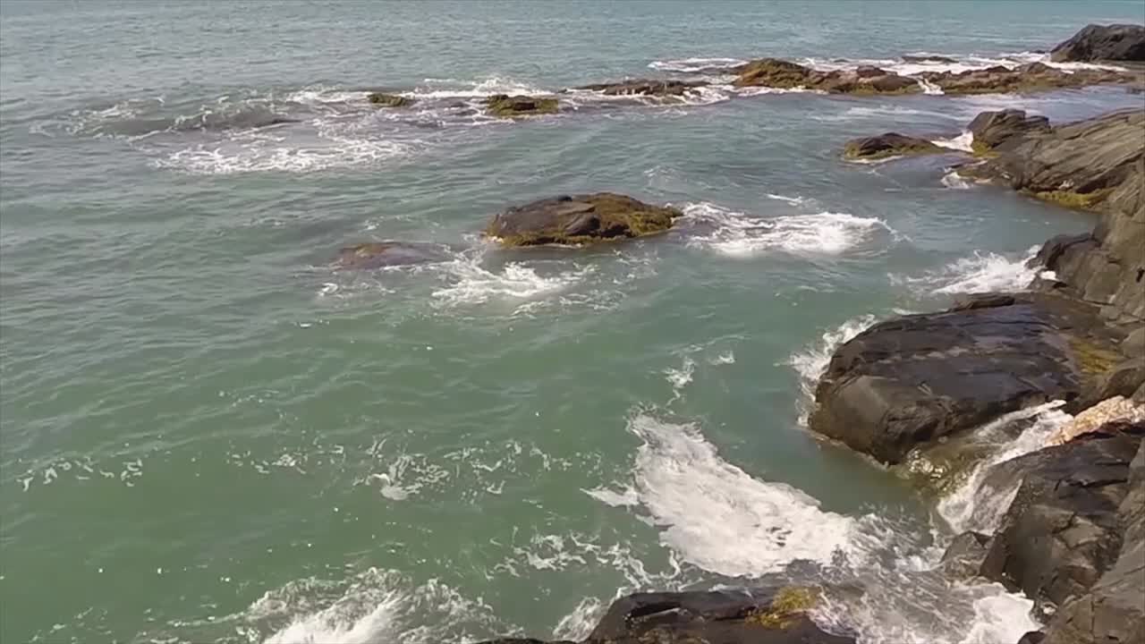las olas del océano chocando contra la orilla rocosa