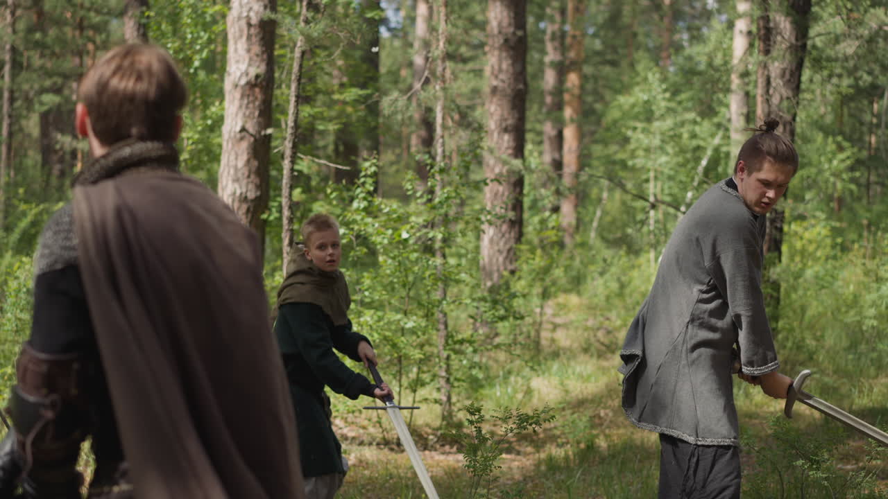 십대 소년 들 은 소나무 숲 에서 주인 과 함께 검 공격 을 훈련 한다