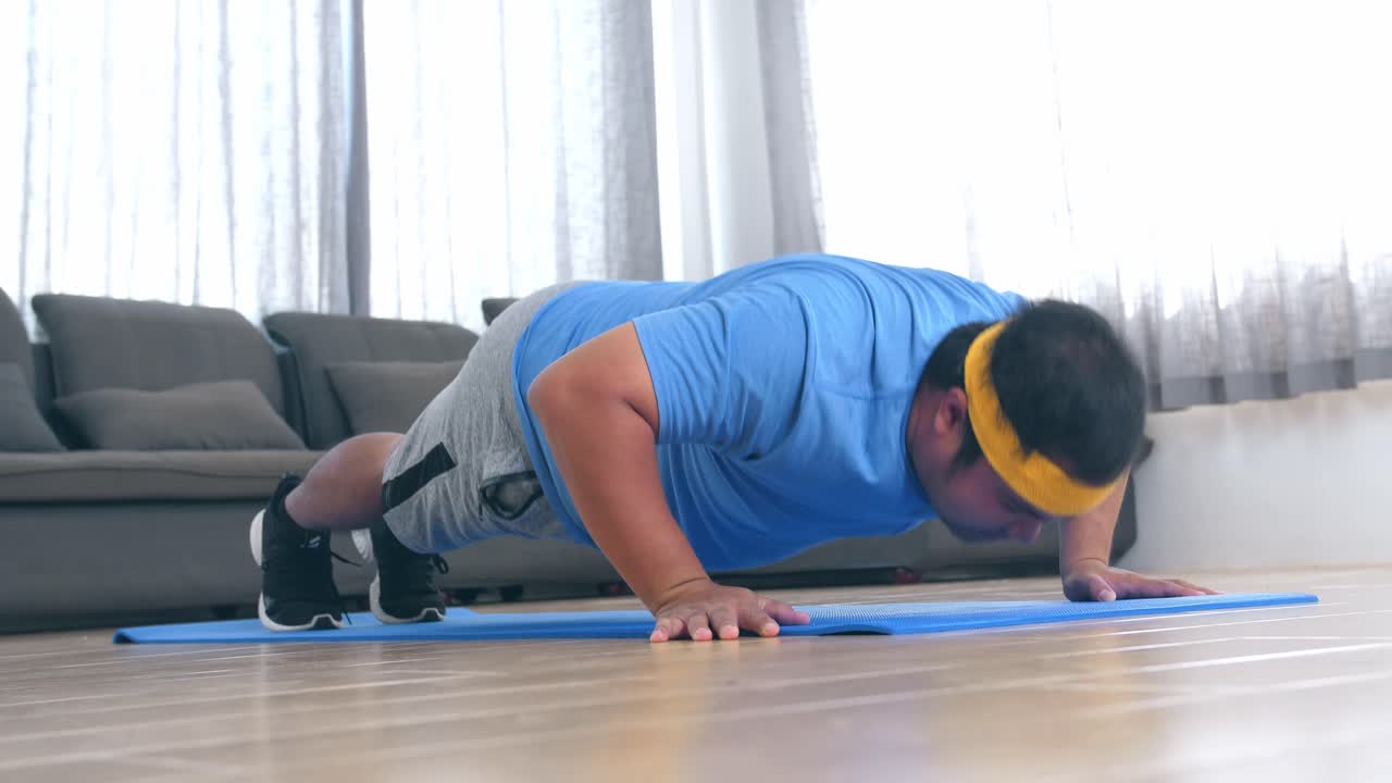 hombre con sobrepeso haciendo flexiones en casa