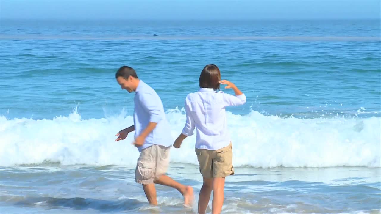 달 ⁇ 한 부부가 물 가장자리에서 놀고 있습니다.