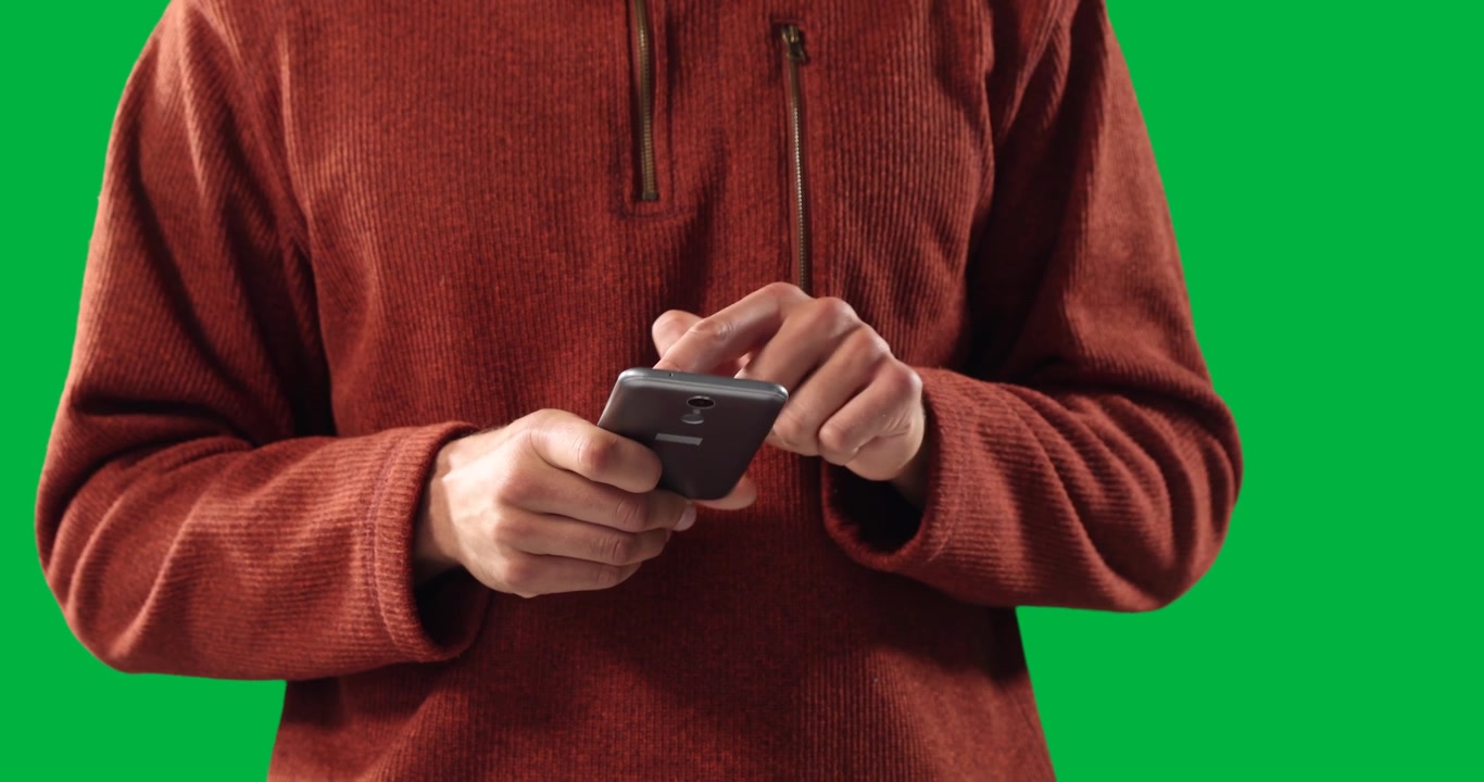 Person Using a Smartphone Against a Green Screen Background
