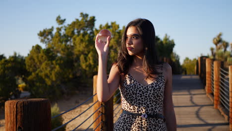 A-pretty-hispanic-woman-with-a-magic-crystal-ball-staring-and-smiling-in-slow-motion-at-sunset