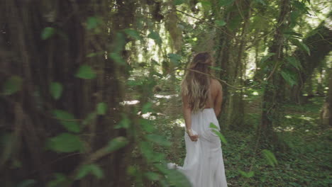 alegre chica rubia con vestido blanco en el bosque de fantasía en maui, hawaii