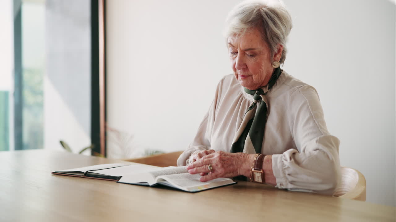 Senior woman reading and writing in a notebook