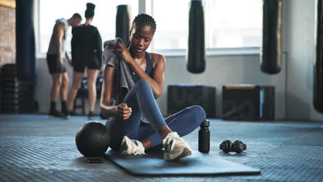 tired, sweat and woman with towel at gym