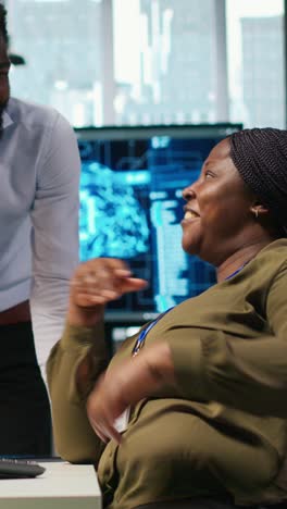 vertical video cheerful programmers in office enjoying conversation while automating with ai