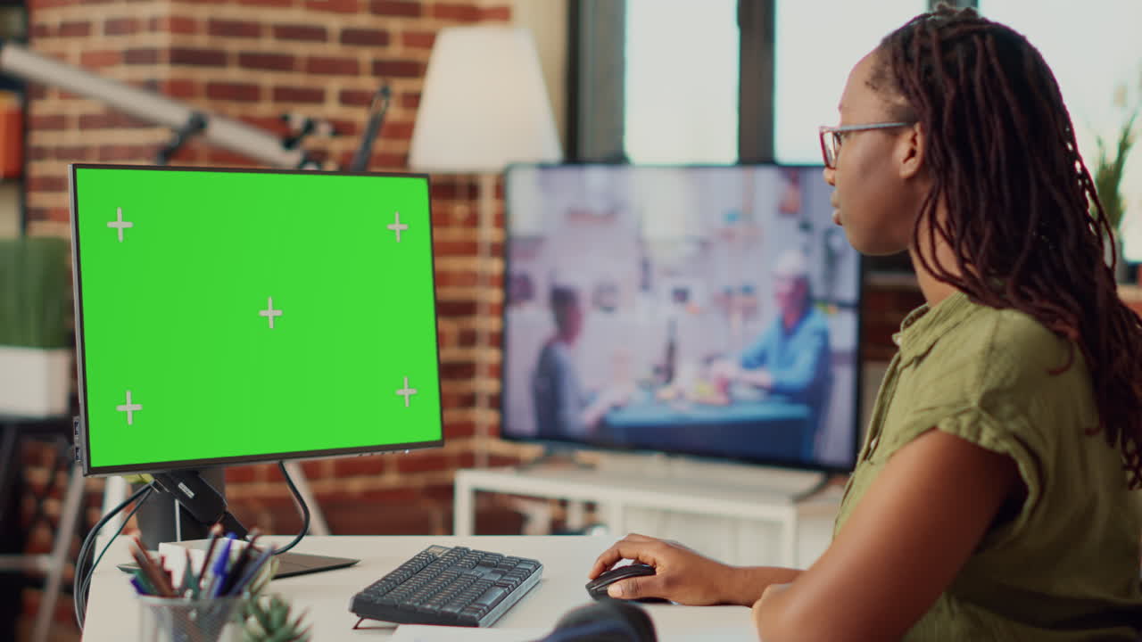 Corporate worker looking at greenscreen display on computer