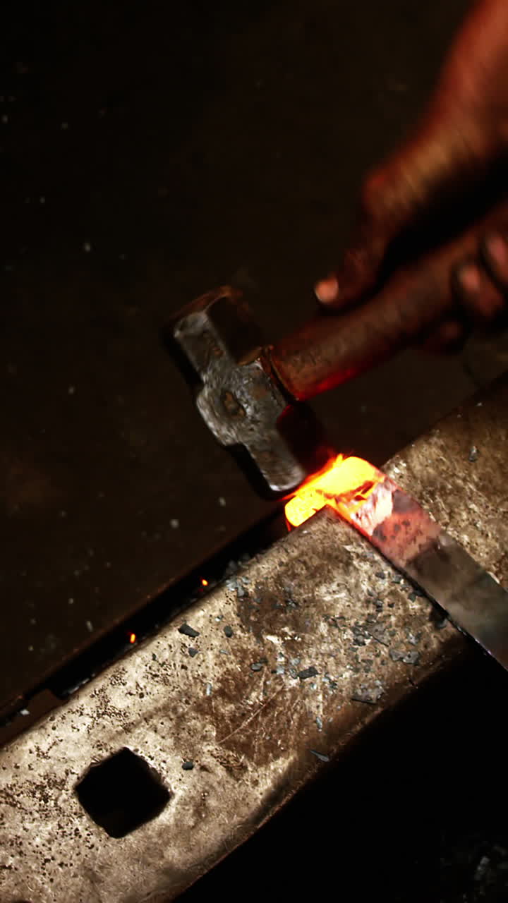 Herrero trabajando en una barra de hierro