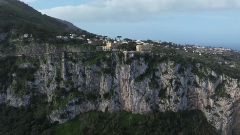 vista del acantilado de capri, italia con edificios históricos y exuberante vegetación, bajo un cielo despejado