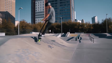 youth riding scooter and performing tricks in a vibrant city skatepark