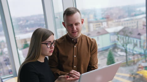 young web designers look at laptop and discuss. teamwork, coworking concepts.