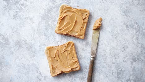 Two-tasty-peanut-butter-toasts-placed-on-stone-table