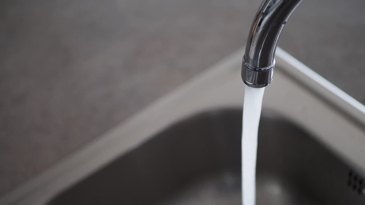 agua que fluye de un grifo de la cocina