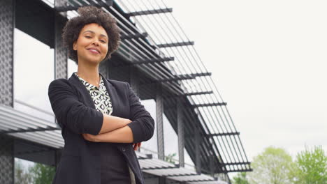 retrato de una mujer de negocios sonriente de pie fuera de un moderno edificio de oficinas