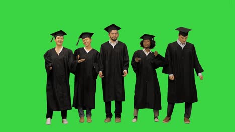 playful girls and guys graduating students dancing on a green screen, chroma key
