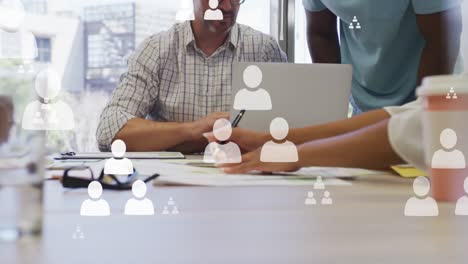 animation of profile icons floating over mid section of colleagues discussing over a plan at office