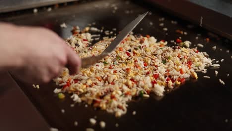 chef preparing delicious fried rice on teppanyaki grill