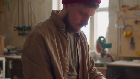 woodworker using ruler and pencil for measuring plank