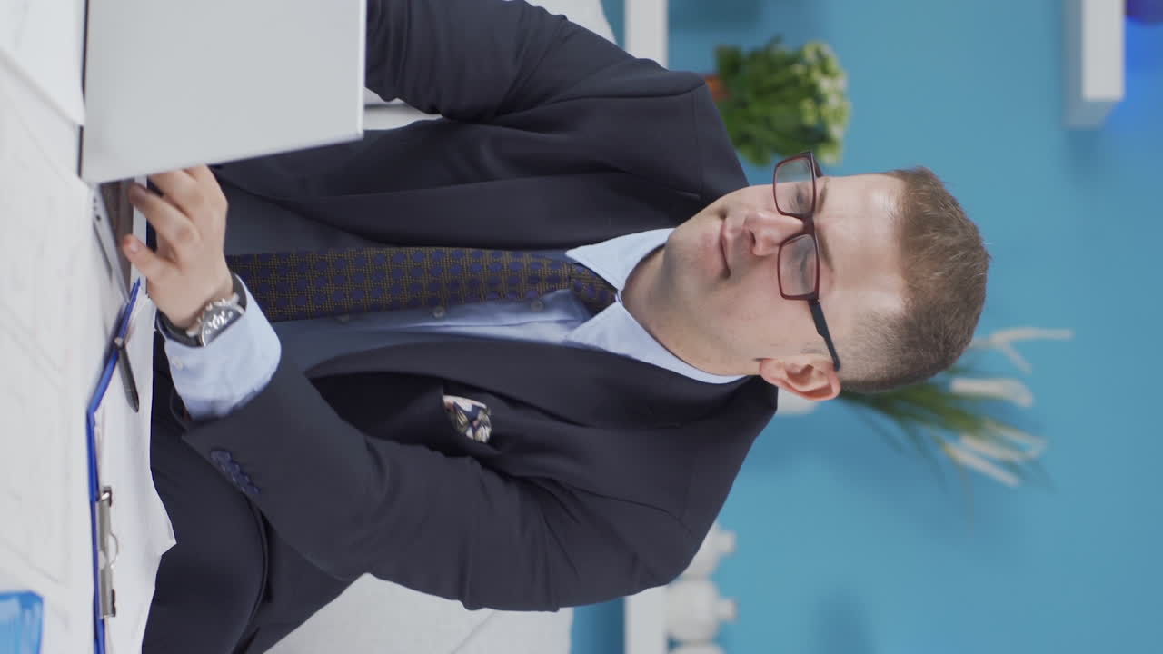 vídeo vertical de un trabajador de oficina en casa centrado en el pensamiento.